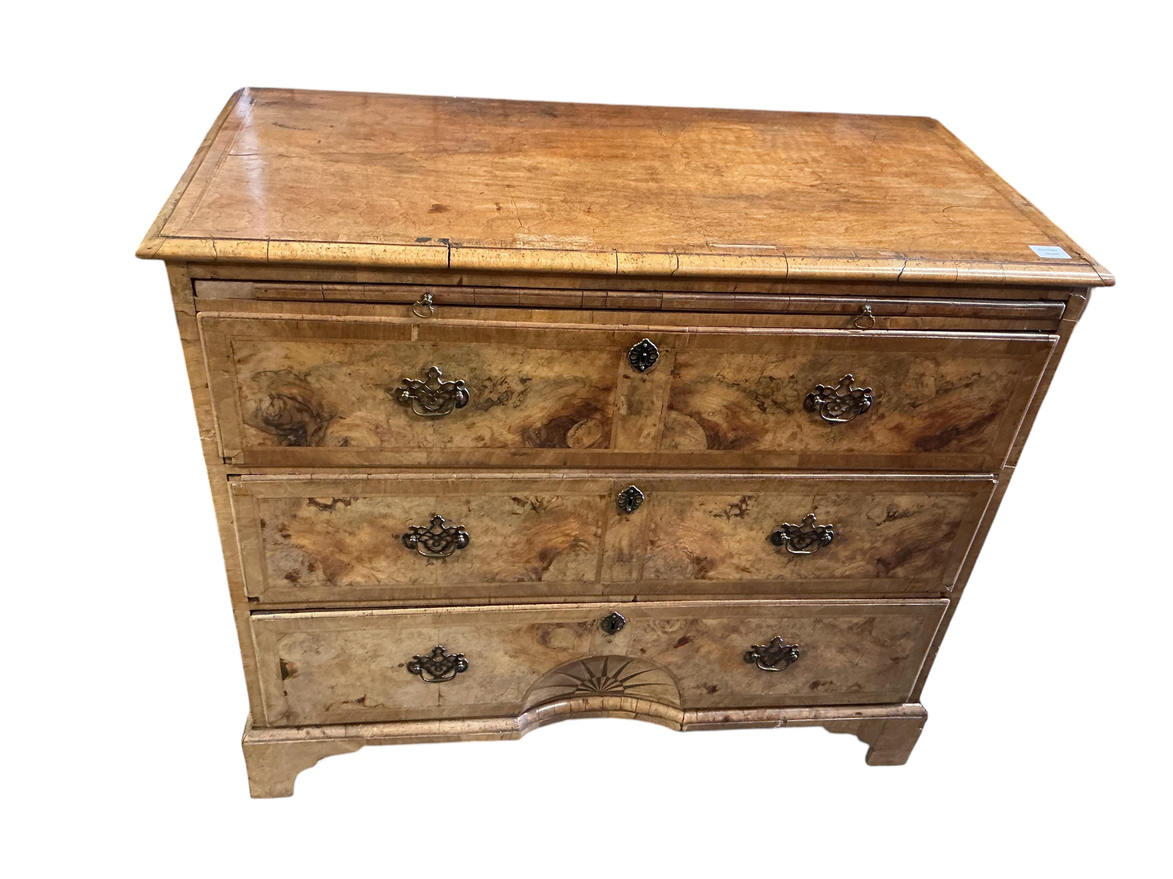A mid 18th century feather banded walnut concave starburst walnut chest of three drawers, with brushing slide, width 108cm, depth 54cm, height 92cm